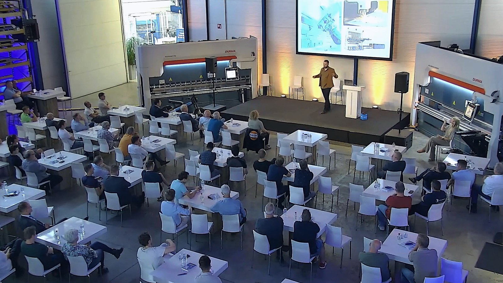 Smart factory-sessie met een volle zaal tussen de machines